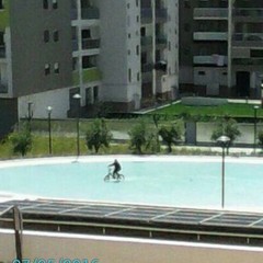 In bicicletta nella piscina del Parco dell'Umanità