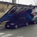 Cartellone pubblicitario cade e schiaccia un'automobile