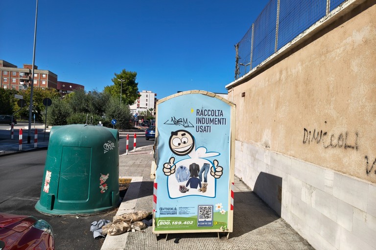 Colonna per gli indumenti usati abbandonata sul marciapiede